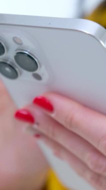 Kanepede oturan telefonu kullanan genç bir kadın. Akıllı telefonla mesaj yazan kişiyi kapat. Yüksek kalite 4k görüntü
