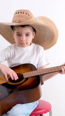 Gitar çalan sevimli çocuk parmaklarını kapat. Çocuklar için müzik okulu. Müzik akorları. Yüksek kalite 4k görüntü