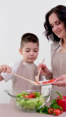 Anne ve küçük oğlu peynirle kaplanmış ballı kahvaltı beyaz arka planda sağlıklı yemekler çay mutfağı önlüğü