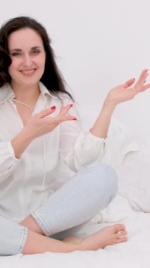 Güzel, beyaz, güzel tişörtlü bir bayan izolasyon üzerinde kalıyor. Gri arka plan parmağını uzak bir yere işaret ediyor. Yüksek kalite 4k görüntü