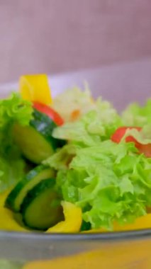 Tahta bir spatula ile cam bir tabaktan sebze salatası karıştırılmış sebzeler, ahşap tahtada sağlıklı gıda konsepti. Yukarıdan bak. Yüksek kalite fotoğraf