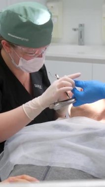 Doktorun elleri anahtar nozülü ve piezoelektrik pullu diş temizleme implantları doku hazırlama ultrasonik ölçeklendirici modern teknolojiler Ukrayna 2023