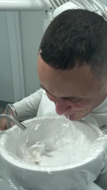 牙科治疗成年男子在治疗后用餐巾纸擦拭面部白沫 — 图库视频影像