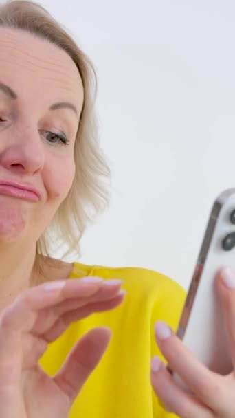 Kvinna Som Håller Mobiltelefon Isolerad Vit Bakgrund Tittar Sidled Med — Stockvideo