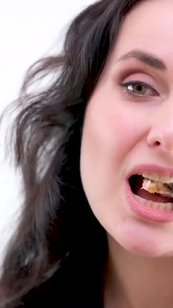 女人吃一块肉 细细地咀嚼着美丽的白皙黑发中年妇女的近照脸 — 图库视频影像