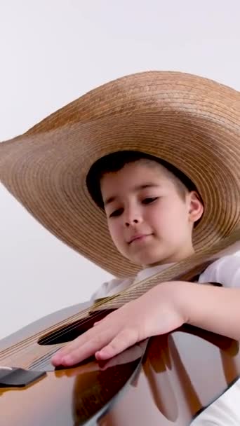 Маленький Хлопчик Сидить Стільці Впевнено Тримає Гітару Руках Грає Білому — стокове відео