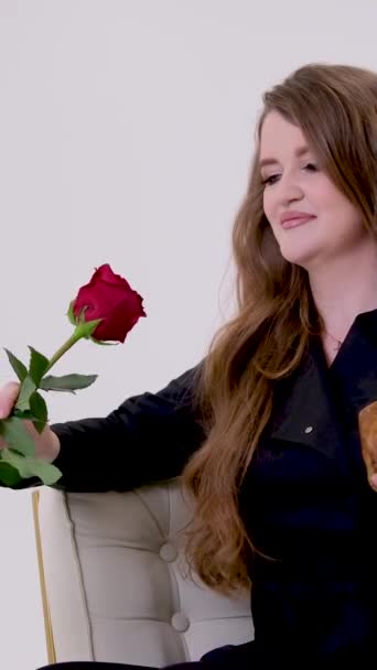 黒の女は片手に赤いバラを手に人間の頭蓋骨陰湿な女の吸血鬼豪華な髪 — ストック動画