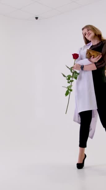 穿着白色医用长袍的高跟鞋女孩在美丽的生活与玫瑰和骷髅休息之间做出选择 — 图库视频影像