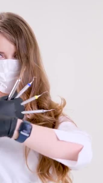 歯医者は黒い手袋をはめた手の歯科器具を手に持っている 歯医者さん 高品質 — ストック動画