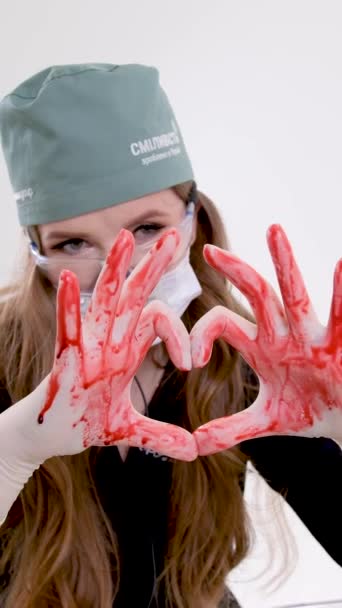 用手拿着心脏在手上放血滴滴牙科双筒望远镜在医生鼻子手术治疗上帮助心脏科咨询乌克兰2023医生 — 图库视频影像