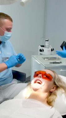 optragate mouth expanderdental clinic doctor and assistant nurse assistant tearing package of sterile instruments while preparing for dental procedures dental treatment whitening filling cleaning