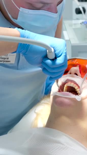 歯茎を漂白剤の作用から隔離する液体コサーダムオパトラット回転式スプレッダー水のジェットで歯科医院で歯を洗浄 — ストック動画