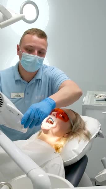 アメリカの歯を使った口拡大術ホワイトニングマシン歯科医院の医師患者に紫外線ランプを引く最新の技術治療歯をきれいにする健康 — ストック動画