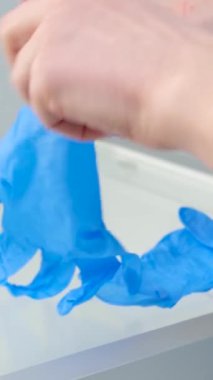 Kadın elleri hijyenik eldivenler giyer, cam masaları siler, dişçi muayenehanesi temizler, temiz sterilite, covid hastane enjeksiyonları yapar, hastaları tedavi eder.