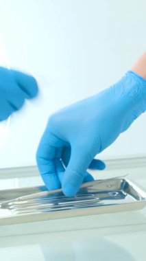 Diş tedavisinden sonra doktor ve hemşire kullanılmış aletleri cam sehpanın üzerindeki steril tepsiye aynı anda koydular.