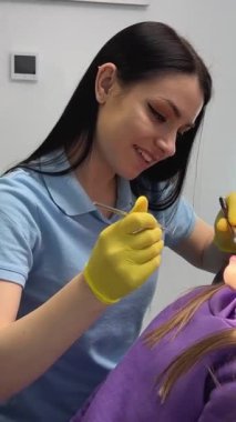 Diş muayenesinde dişçi koltuğunda oturan sevimli küçük kız. Çocuklar dişçilik kliniğinde doktorculuk oynuyor. Pediatrik dişçilik. Gelecekteki mesleğe aşina olma kavramı