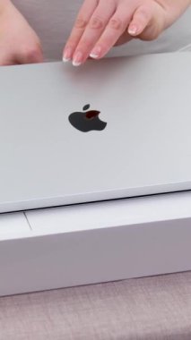 Macbook 14 'ün yeni dizüstü bilgisayarını M1' den açarak Apple 'ın yakın plan elma ikonlu kadını bilgisayarı çeviriyor. 