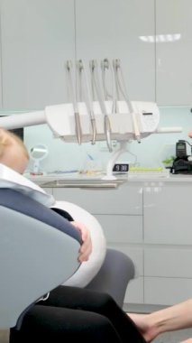 Genç doktor dişçi koltuğunu ilk kez gösteriyor. Mutlu bir mutluluk gülümsemesi. Hoş sohbetler. 