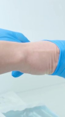Individual protection products vinyl disposable gloves in spread of virus and protection against infections. Women is dressing her hands in gloves. The coronavirus protection trend is COVID-19.