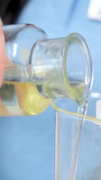 Nahaufnahme Professionelle Wissenschaftler Gießt Klare Gelbe Flüssigkeit Aus Extrahiert Laborglas — Stockvideo