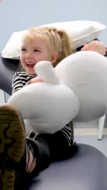 Молодой Врач Показывает Маленькой Девочке Стоматологическое Кресло Первая Поездка Стоматологу — стоковое видео