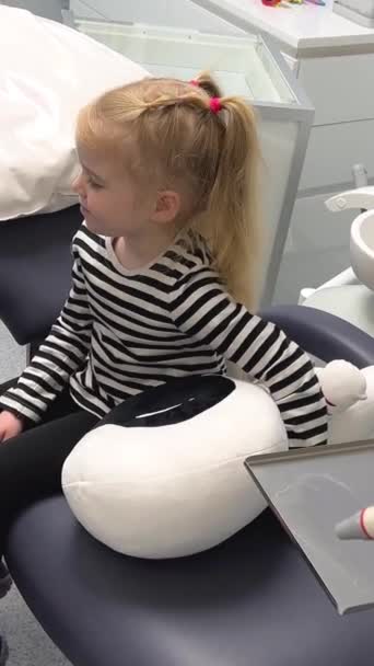 第一次见牙医时 女孩坐在椅子上 看着医生 她害怕最新的技术 直着背走路 — 图库视频影像