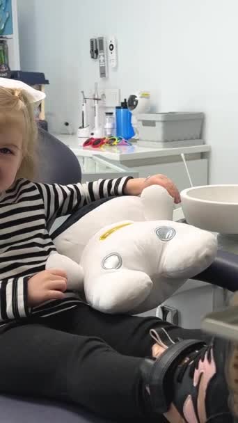 Çizgili Bluzlu Küçük Bir Kız Dişçi Ofisinde Yumuşak Bir Oyuncakla — Stok video