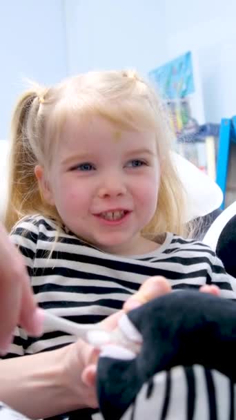 의사는 어린이에게 치아를 방법을 주는데 소녀는 미소를 것처럼 보이며 칫솔을 — 비디오