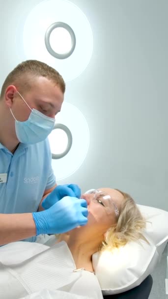 牙科诊所医生在牙科诊所行医前 先把橡胶坝牵引器放进嘴里清洁牙齿美白充填假肢根管治疗医生 — 图库视频影像