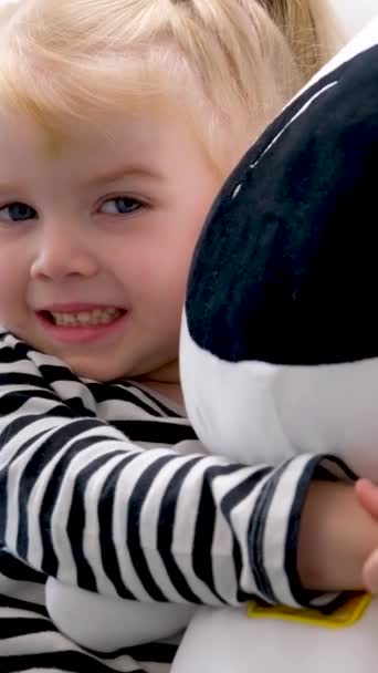 Zbliżenie Mała Dziewczynka Miękki Zabawka Ręce Pokazuje Język Wygląda Nieśmiały — Wideo stockowe
