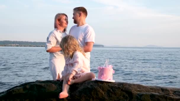 夫妻俩带着女儿在海上欢度了一个小孩的三周年纪念日 在家庭中 爱与幸福是相互谅解的温情 — 图库视频影像