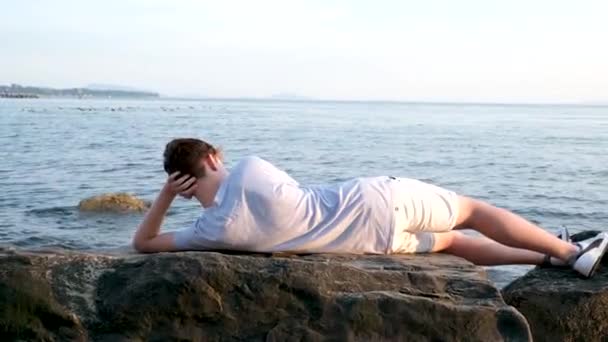 Dospívající Chlapec Leží Pláži Stone Shore Ležet Big Stone Slunečný — Stock video