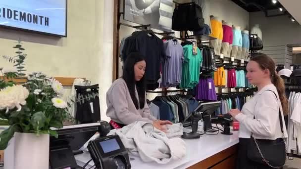 Lululemon Kauft Sportbekleidung Grauen Trainingsanzug Geschäft Der Kasse Mädchen Verkäufer — Stockvideo