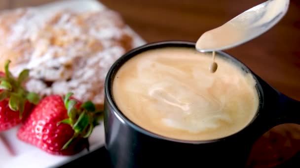黑杯子咖啡 泡沫汤匙草莓羊角面包美味咖啡与小麦 高质量的4K镜头 — 图库视频影像