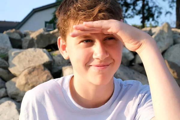 男の子ティーンエイジャー14 16歳は距離に笑みを浮かべて彼の手のビーチで太陽をカバーしていますピクニック思慮深い夢の未来ヨーロッパ — ストック写真
