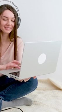 İnternette çalışan dizüstü bilgisayarda yazan genç bir iş kadını, bilgisayar teknolojisi kullanan güzel bir kadın profesyonel kullanıcı ya da internet üzerinden iş yapan ya da ev kulaklığı takan bir internet sitesi olan bir kadın.