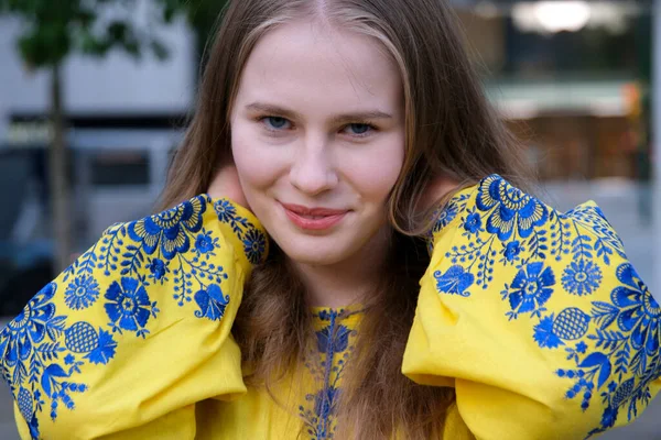 黄色衬衫 蓝色的花 漂亮的小女孩 女人笑着看着镜框里的蓝眼睛 乌克兰国旗的颜色和衣服一样 — 图库照片