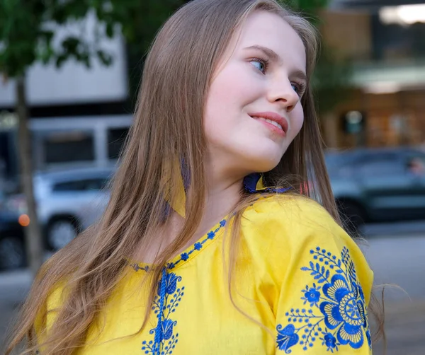 黄色衬衫 蓝色的花 漂亮的小女孩 女人笑着看着镜框里的蓝眼睛 乌克兰国旗的颜色和衣服一样 — 图库照片