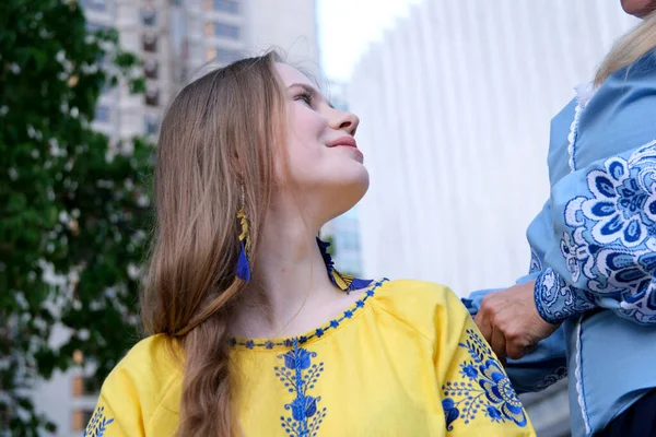 母亲和女儿爱母亲直直的头发 并带去乌克兰战争中的乌克兰难民 乌克兰街头旗帜上俄罗斯黄色Vyshyvanka蓝色传统服饰的侵略 — 图库照片