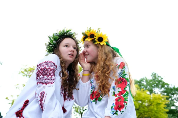 身披花圈的乌克兰姑娘们穿着传统的乌克兰服装 坐在那里兴高采烈 彼此窃窃私语的流言蜚语令人感兴趣地听到深色金发女郎朋友们的民族服装 — 图库照片