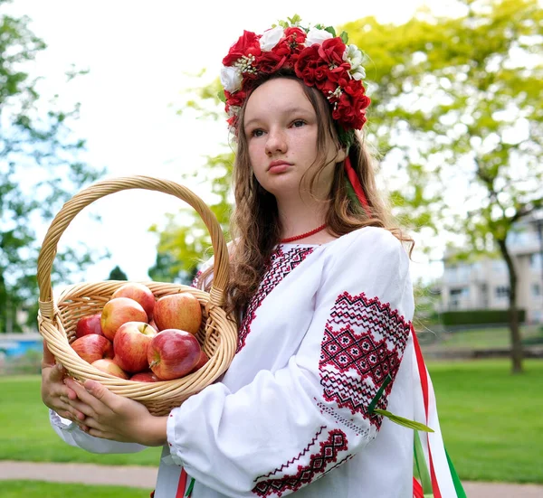 一个漂亮的女孩从篮子里看过去 手里拿着罗文浆果 面带微笑 在罗曼树旁边的一个漂亮女人的画像 传统服装 高质量的 — 图库照片