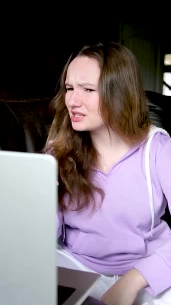 感情的な会話インターネット上の不満10代の少女10代の若者は紫色のパーカーで自分自身を指を指すと悪意のあるラップトップ画面オンラインレッスンに向かって — ストック動画