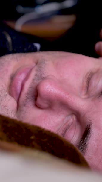 满脸胡须的男人在家里躺在靠近气球的沙发上 头疼地醒来 摸着脸 高质量的4K镜头 — 图库视频影像