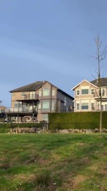 Özel sektör manzarası Yüksek bir tepe, mavi gökyüzü ve yeşil çimen yarılanma alanı zengin özdeş üç katlı evler için Surrey Vancouver Kanada 2023