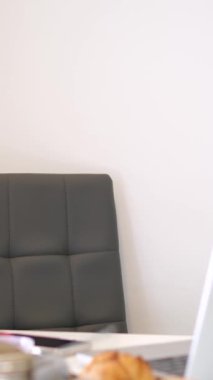Modern mutfakta Uluslararası Kadınlar Günü kutlamalarında servis edilen yemek masası ve vazo. Kahvaltı çörekleri için dizüstü bilgisayar sarısı laleler.