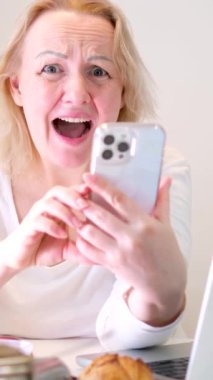 Bir kadın mesaj yazıyor ya da bir site açıyor gibi görünüyor. Sonra da ekranı reklam için yeşile çeviriyor. Gülümseme puanları. 