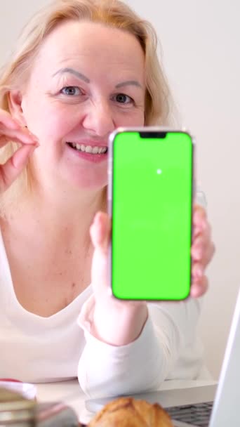 女人竖起大拇指给她的手送气吻绿色屏幕彩色键电话推荐旁边的笔记本电脑黄色郁金香早餐女人 — 图库视频影像
