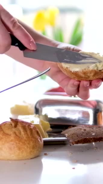 女手用刀叉在浓密的新烤的无酵母面团黄油面包上 自制早餐白桌 在玻璃杯中享用美味的糕点牛奶 — 图库视频影像