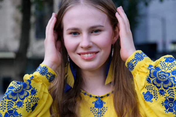 年轻的乌克兰妇女绣花衬衫直视微笑 一头金发模糊了背景特写耳环的形式是乌克兰国旗胜利喜悦的力量自由意志 — 图库照片