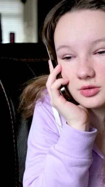 少女在黑暗的房间里用电话交谈淡紫色衬衫飘扬的头发不同的情绪青少年青春期解决与朋友交流的问题 — 图库视频影像